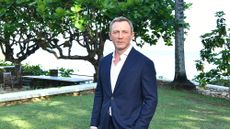 Daniel Craig poses for a photo dressed smartly in a garden