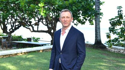 Daniel Craig poses for a photo dressed smartly in a garden