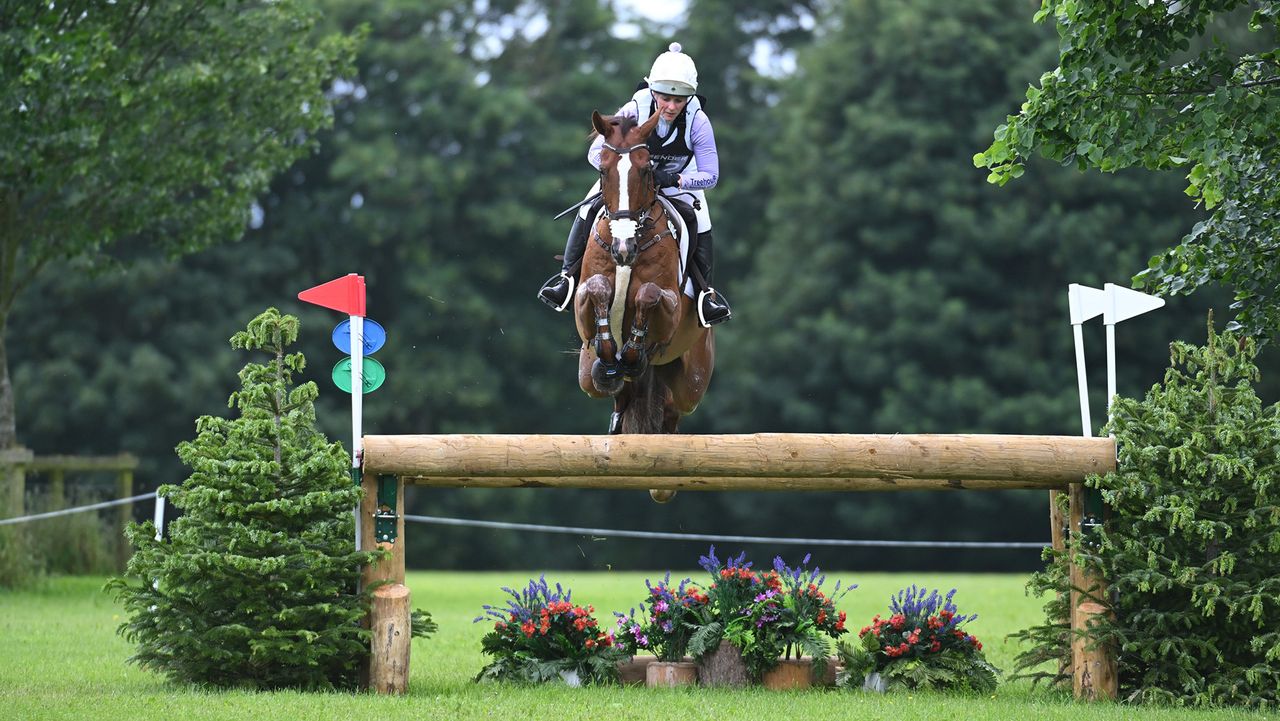 Gemma Stevens, a rider in a purple top and white hat cover, rides chestnut horse Chilli&amp;rsquo;s Jester at Bramham Horse Trials 2026