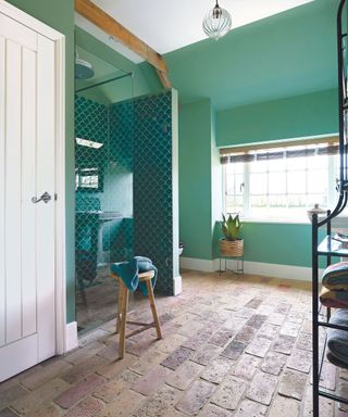 Green tile shower, green walls, stone floor