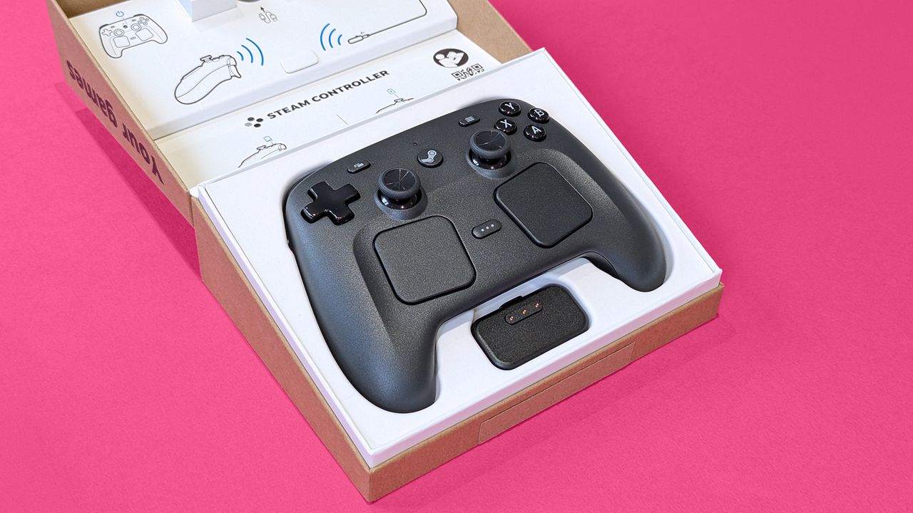 Valve Steam Controller (2026) in its open retail box against a magenta card background
