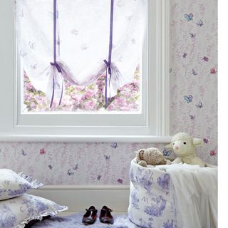 child's bedroom with butterfly design wallpaper and cushions