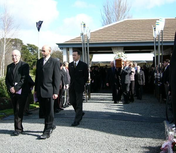 Pastor Murray Lydeamore AIS cycling chaplain (left), and Monsignor Henry Nolan, lead the pallbearers from the chapel.