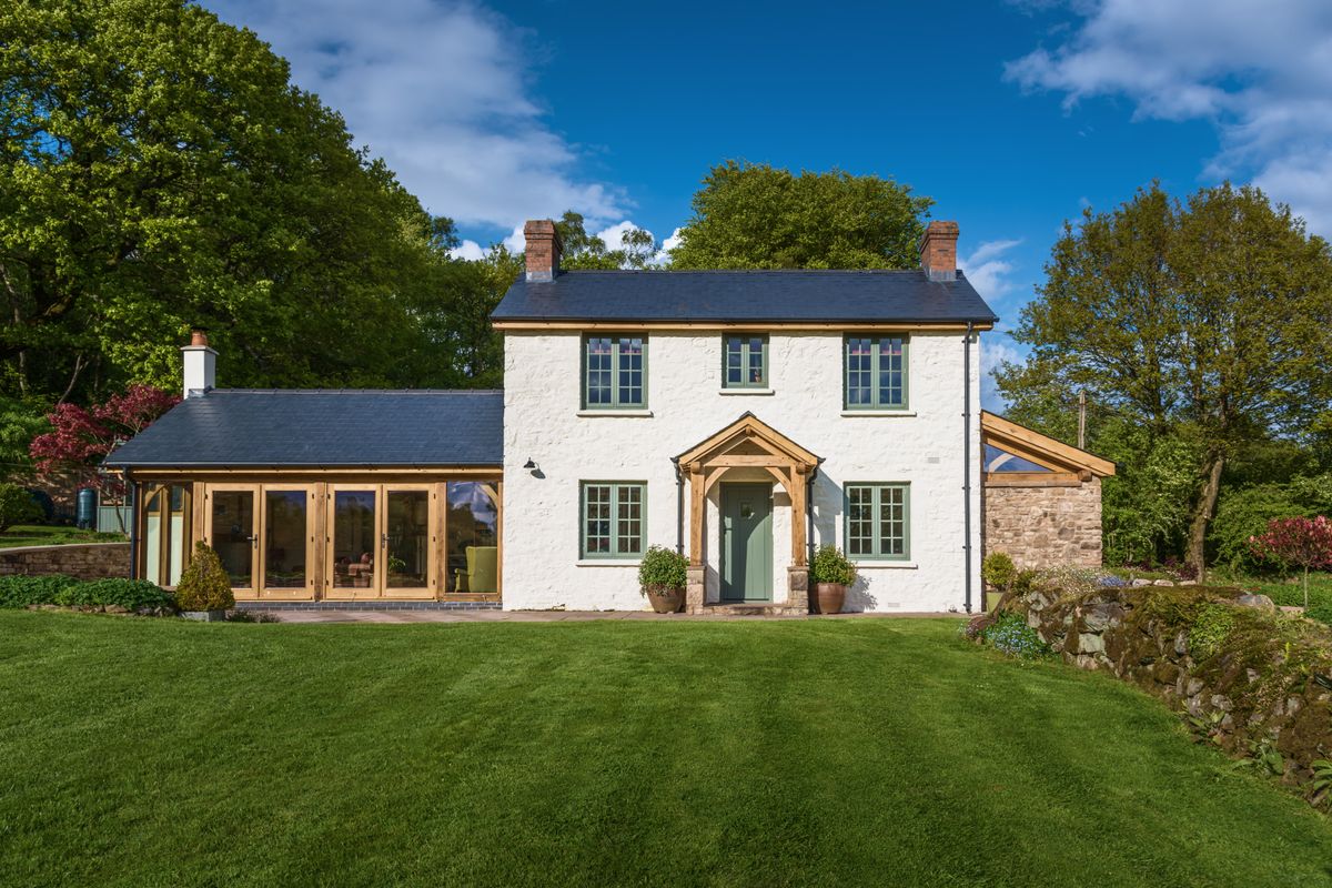 white cottage with timber side extensions