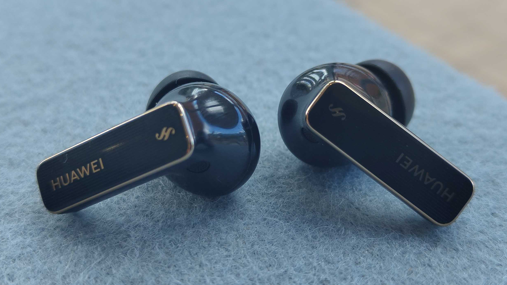 Huawei FreeBuds Pro 4 in-ear headphones on blue fabric
