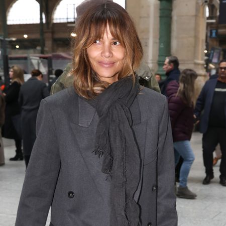 Halle Berry wears a gray coat with a gray scarf.