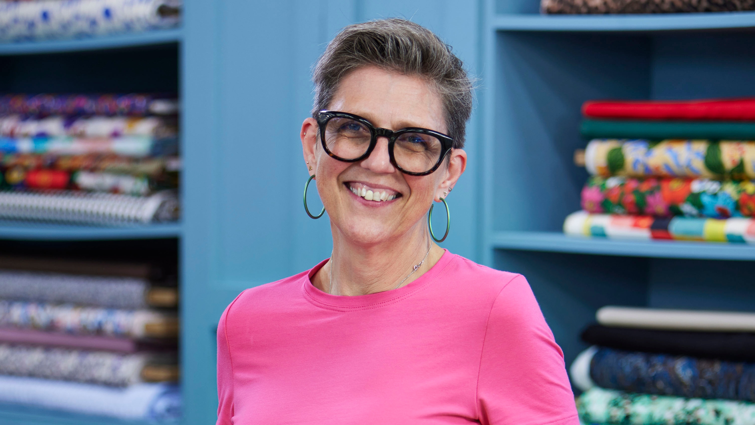 Caz standing in the Great British Sewing Bee studio and smiling for the camera