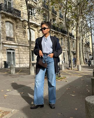 Influencer slip Into Style in Paris in a chic French fall outfit, with wide-leg jeans, loafers and a pinstripe blazer