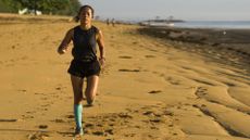 Best compression socks for running: Outdoors fitness portrait of young attractive and athletic Asian Indonesian woman in compression socks jogging on the beach doing running workout training hard in healthy lifestyle concept