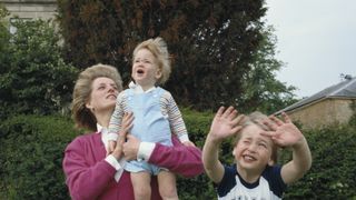 Princes William and Harry with their mother, Diana, Princess of Wales (1961 - 1997) in the garden of Highgrove House in Gloucestershire, 18th July 1986. William is wearing a Dallas Cowboys t-shirt.(Photo by Tim Graham Photo Library via Getty Images)