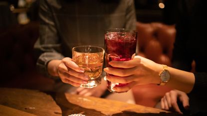 Young female friends toasting glass after work