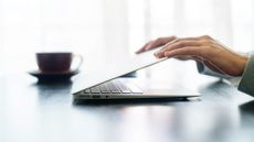 Pair of hands shutting a laptop screen closed