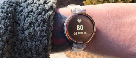 Garmin Lily smartwatch worn on a wrist outdoors with the heart rate measurement feature on the display.