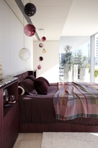 A purple bedroom with dark purple sheets