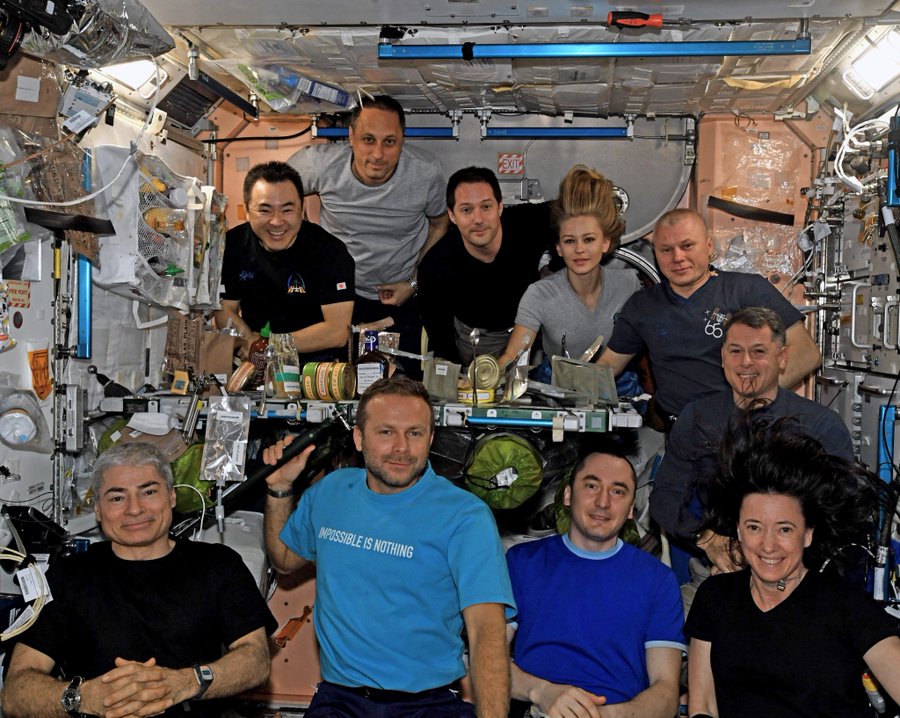 The 10 people living and working on the International Space Station share dinner in a photograph shared by cosmonaut Oleg Novitsky on Oct. 14, 2021.