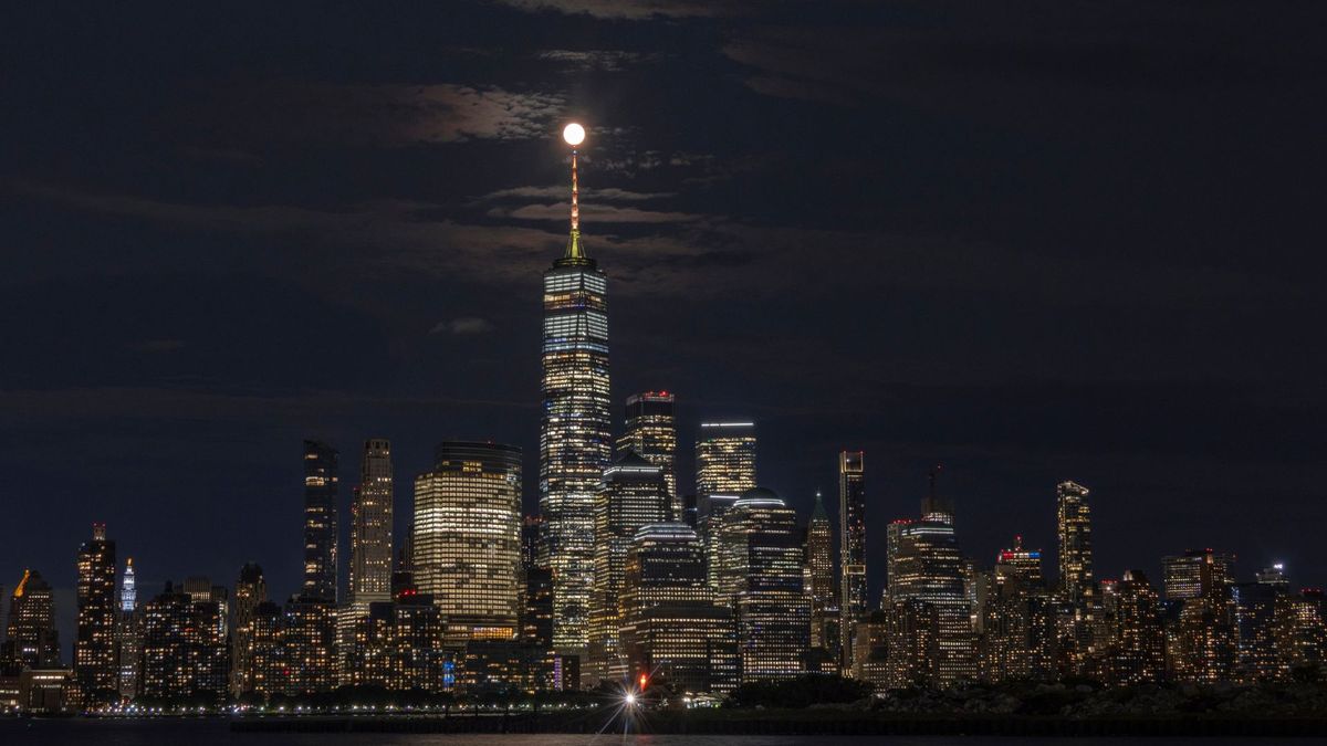 Por la noche, la luna llena brilla sobre el horizonte de la ciudad de Nueva York.