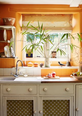Vanessa Arbuthnott orange kitchen blinds in cream kitchen with vintage style cabinetry