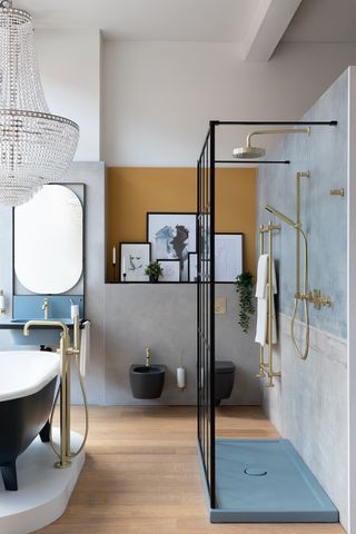 A bathroom layout featuring a neat walk-in shower, a black rolltop bath and a small sink