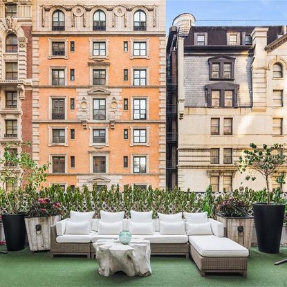 orange building and balcony with sofa sets with white cushions