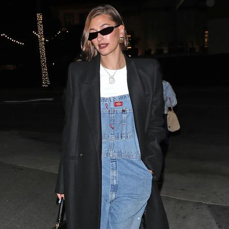 Hailey Bieber wearing black coat and overalls