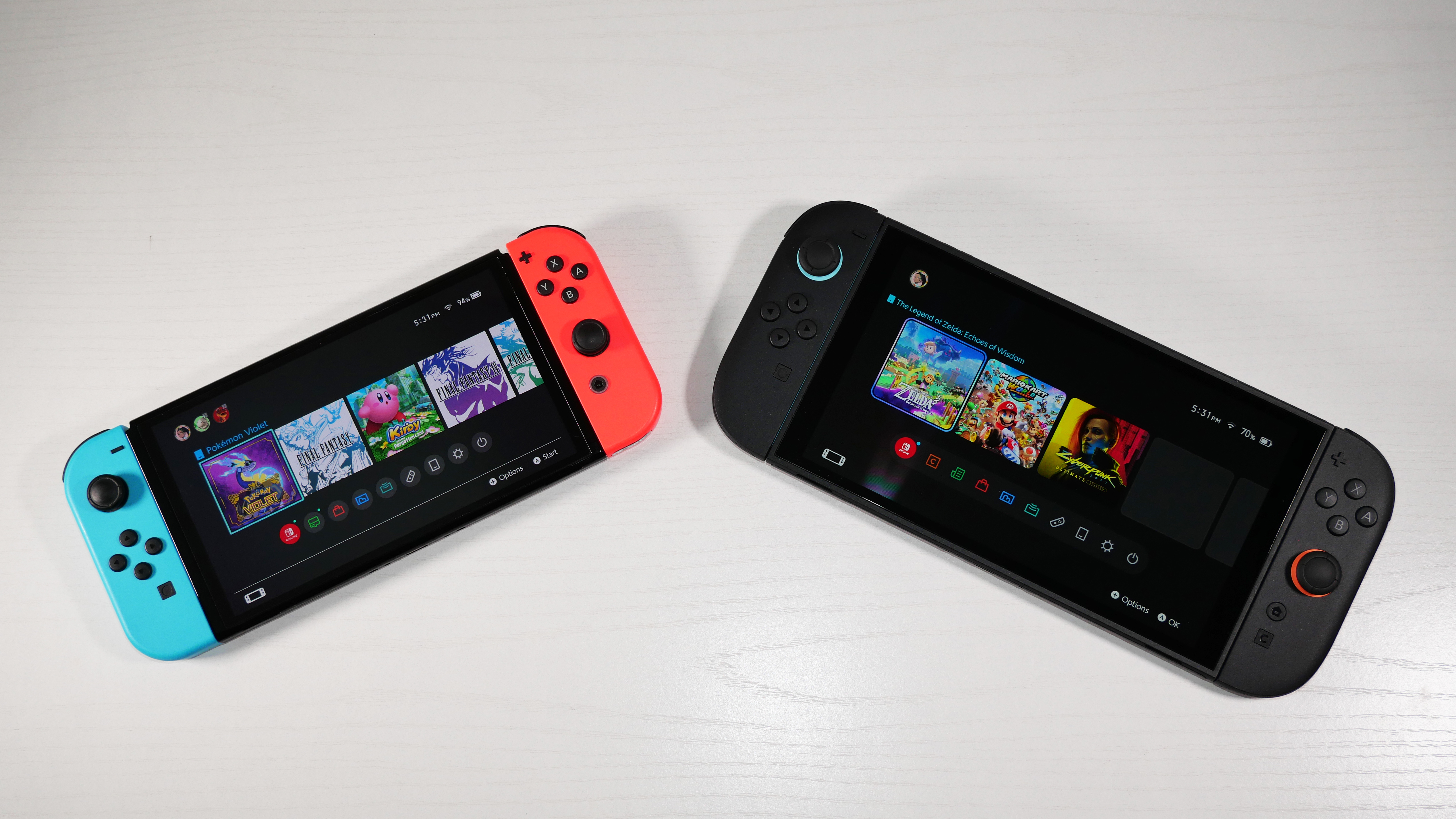 Nintendo Switch 2 and Switch OLED side by side on a white desk at an angle.