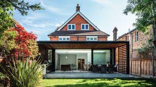 large brick house with modern extension added including large sliding patio doors