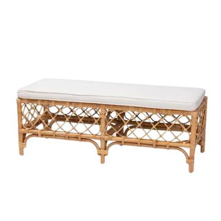 A rattan wooden bench with a white upholstered seat