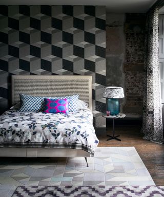 Graphic wall decor for bedrooms with a geometric print accent wall and contrasting graphic, floral and spotted patterns throughout the scheme.