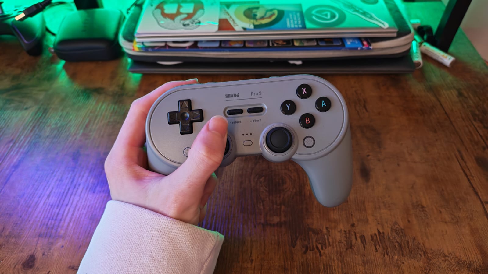 A reviewer holding the 8BitDo Pro 3