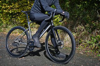 Male cyclist sitting on the top tube of the Ribble Allroad Ti Pro