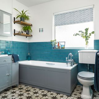 bathroom with white with blue tiled walls and wooden racks on walls