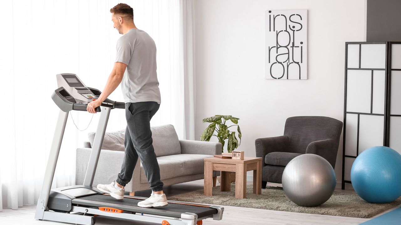 A man on a treadmill at home in his living room