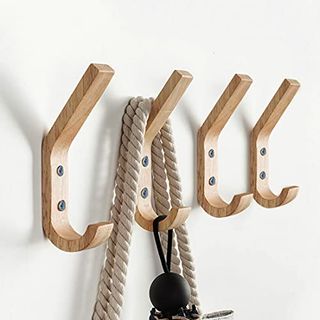 Four wooden wall hooks, double hooks. second hook has a rop hanging over it. 