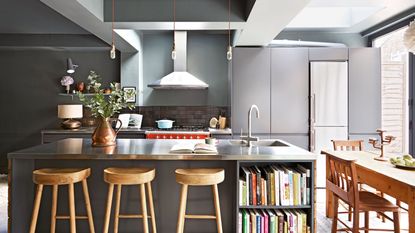 modern kitchen with stainless steel island, wooden bar stools and cookbooks