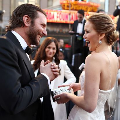 Bradley Cooper and Jennifer Lawrence share a moment of laughter on set