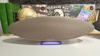 Bowers & Wilkins Zeppelin Pro Edition wireless speaker on white shelf with books and globe in background