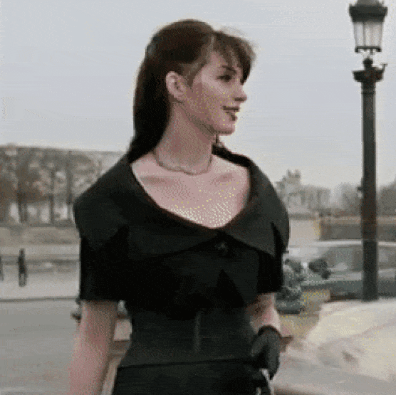 Woman in black dress throwing stone in a fountain gif
