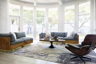sunroom with large rug and modern sofas and armchair