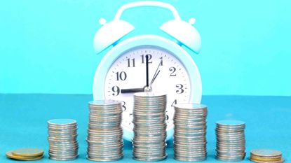 Photo of stacks of coins in front of a clock