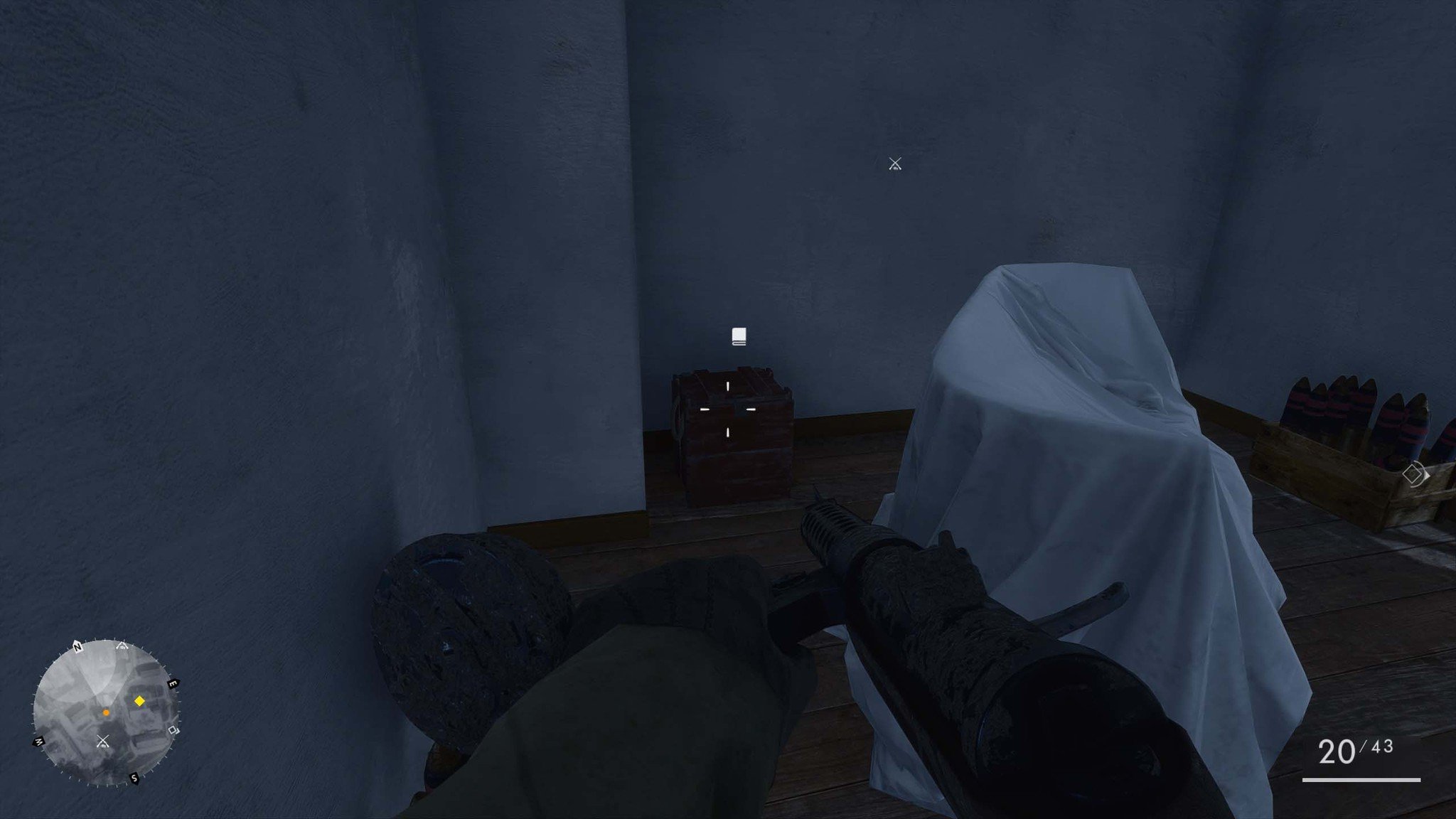 The field manual is located in the room with the covered sofa.