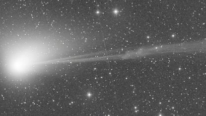 A still image of the green comet C/2022 E3 as a solar explosion rips part of its tail away