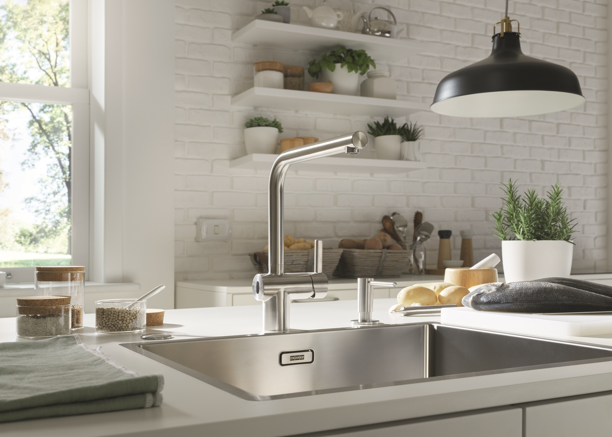 A modern kitchen tap with hands-free sensor controls shown with a stainless steel sink