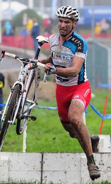 Shimano NEPCX Series leader Christian Heule (Cannondale p/b Cyclocrossworld) running the barriers in the rain