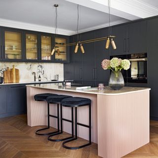 kitchen with pink breakfast bar and bacl cabinets with reeded glass doors