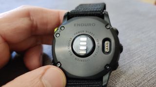 fitness tracker vs running watch: a back of Garmin Enduro showing the sensor