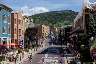 Colorful buildings line Main Street in Park City, Utah with the green mountains in the background