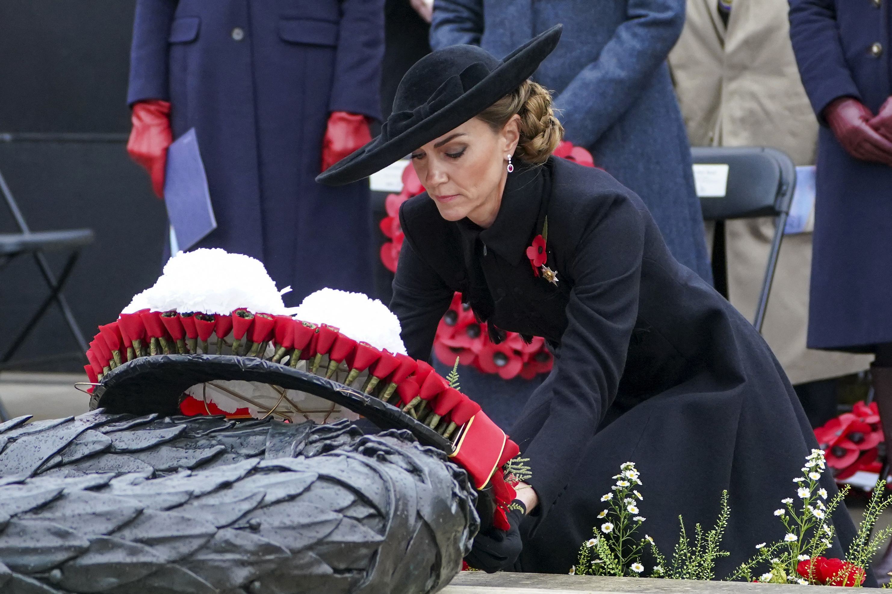 Kate Middleton wearing a black coat laying a wreath at an Armistice Day event