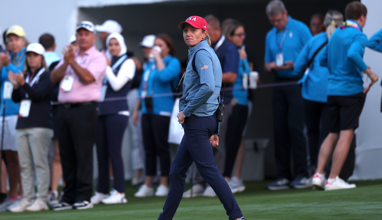 Stacy Lewis walks down the fairway whilst speaking on her headset