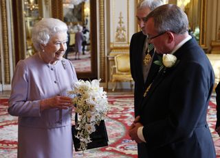 Queen Elizabeth II is presented with a replica of the Coronation Bouquet by the Worshipful Company of Gardeners
