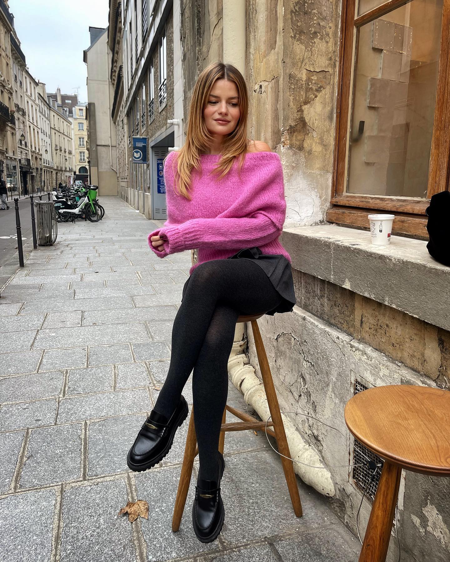 @sabinasocol sitting on a stool in Paris with a '90s layered haircut